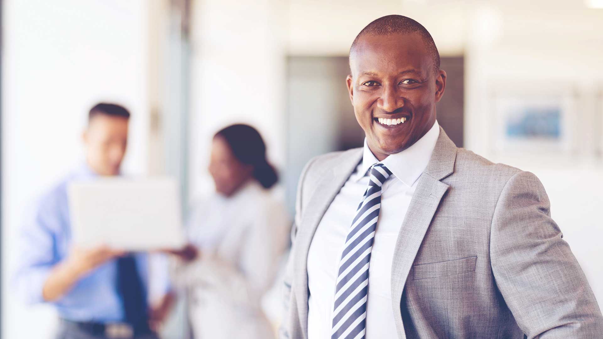 Black man in suit smiling at the camera