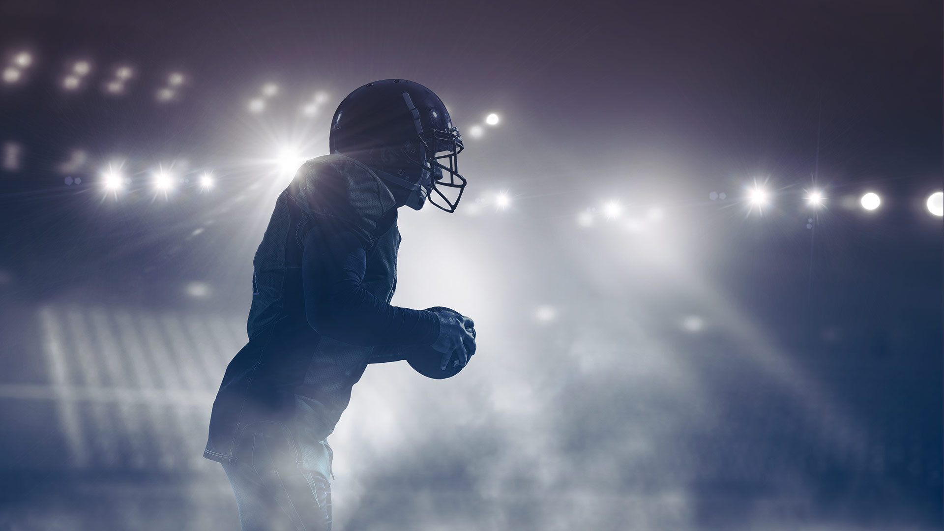 Profile of a football player under the stadium lights